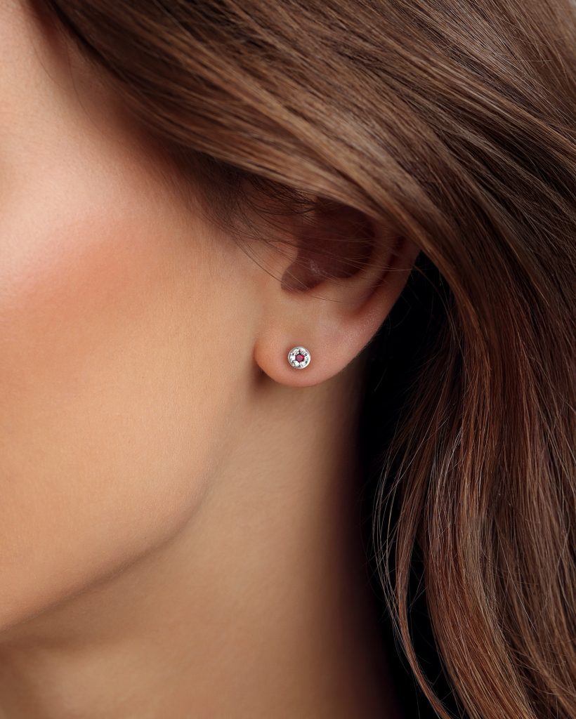 Aukso studs auskarai su rubinais ir deimantais moters ausyje